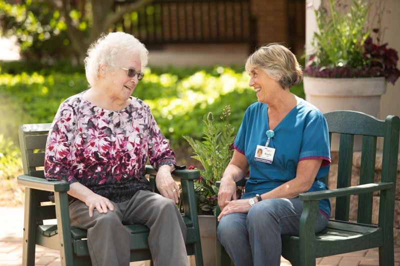 Female resident talking outside with female health care worker