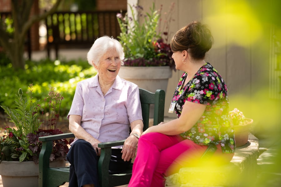 Resident and healthcare worker talking outside