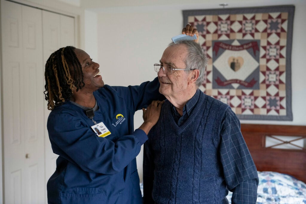 Caregiver combing residents hair